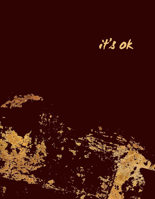 Visszafogott, mégis kifejező design szerepel a képen, ahol a "it's ok" szöveg aranyló betűkkel tör elő a mély, sötétbarna háttérből, mintegy üzenetet küldve a viselője által. 