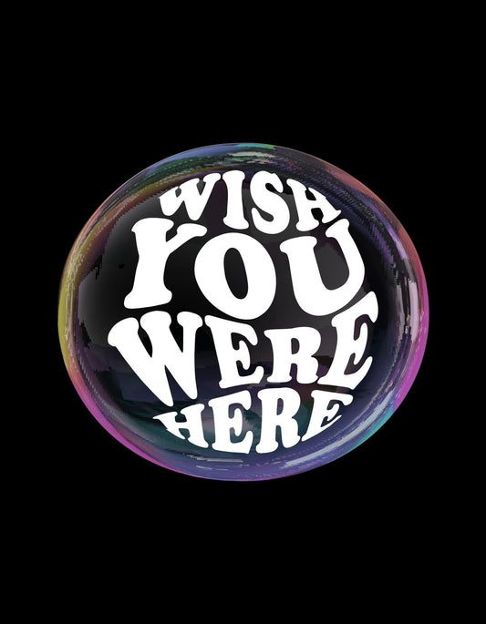 Egy gömb alakú, tükröződő felületre írt "WISH YOU WERE HERE" felirat látható a képen, fehér betűkkel, melyek kiemelkedő kontrasztot alkotnak a fénylő, szivárványszínű háttérral. 