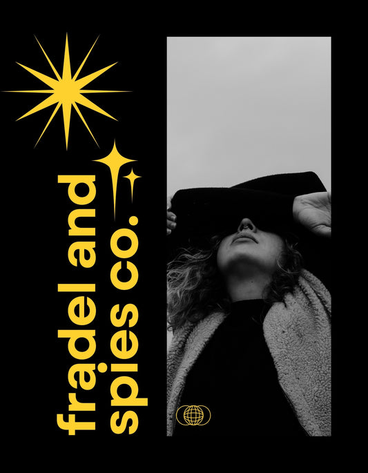 Egy stílusos női portré, aki fekete kalapot visel, alul egy világos kabátban, sötét hátteren, mellette egy arany csillagos design és a "fradeland spies co." felirat. 